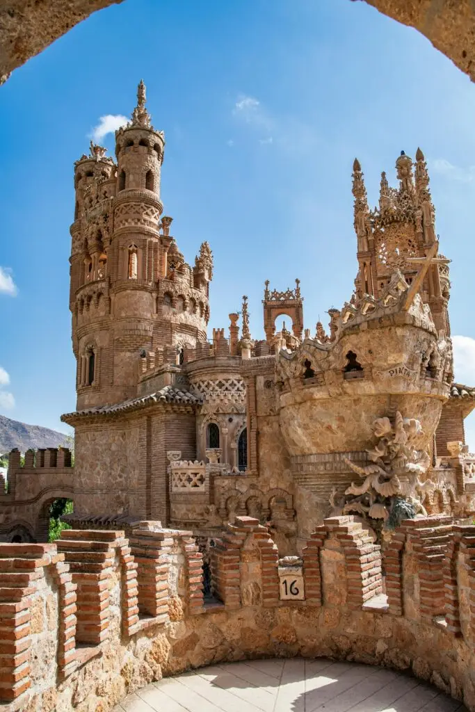 Explore the detailed architecture of a historical stone castle under a bright blue sky.